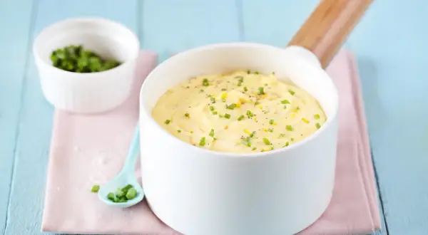 Un bol de beurre citronné (pour poisson) garni de ciboulette et de zeste de citron, prêt à sublimer votre plat.