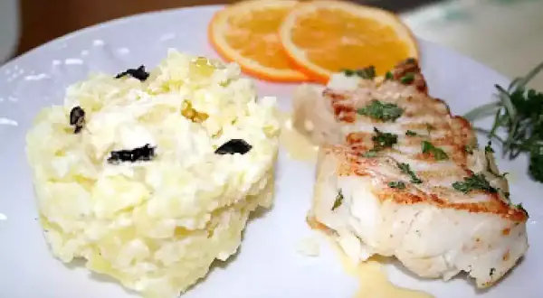 Dos de cabillaud poêlé, purée de pommes de terre aux olives, garni de sauce maltaise et de rondelles d'orange.
