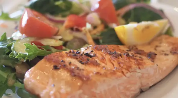 Un délicieux filet de saumon grillé, parfaitement assaisonné, servi avec une salade fraîche et colorée. Un accompagnement poisson idéal pour un repas léger et savoureux.