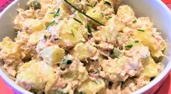 Salade de pommes de terre et thon crémeuse, garnie de ciboulette fraîche. Un délice pour un repas léger.