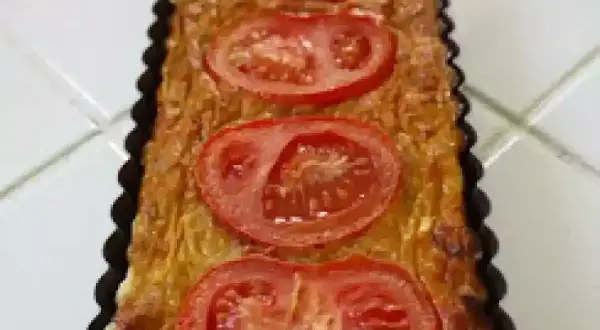 Quiche rectangulaire garnie de thon, tomate et moutarde, prête à être dégustée.