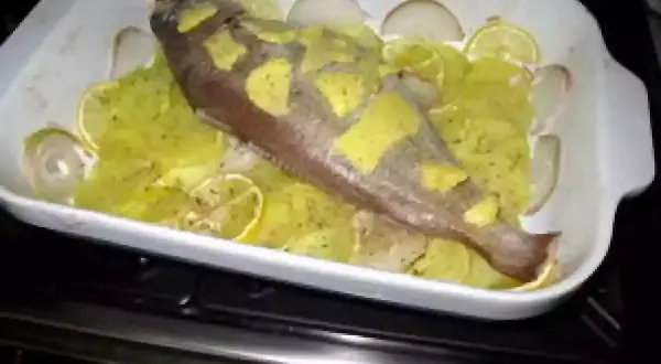 Poisson entier préparé pour la cuisson, avec des rondelles de citron et d'oignon. Une belle tacaud recette en préparation.