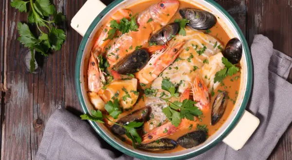 Un plat de bouillabaisse savoureux avec poissons, crevettes et moules, prêt à être dégusté. Une recette authentique pour un repas d'exception.