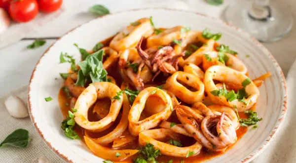 Délicieuse cuisson lamelle d'encornet à la poêle, garnie de persil frais. Un plat savoureux et coloré.