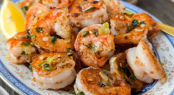 Crevettes sautées chinoises, parfumées à l'ail et à la ciboule, servies avec un quartier de citron. Un délice !