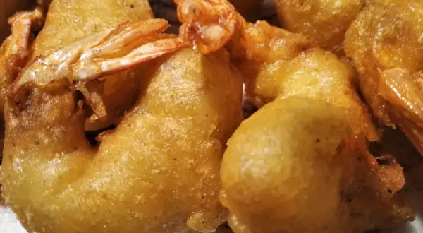 Gros plan sur des beignets de crevette dorés et croustillants, prêts à être dégustés.