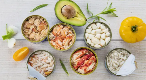 Six boîtes de crabe préparé pour la cuisson, avec avocat, tomate jaune et oignons verts.