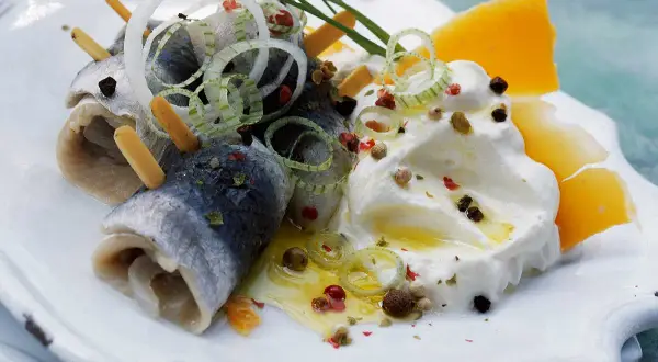 Délicieuse rollmops recette : harengs roulés, oignons, fromage et crème, assaisonnés de poivre et d'herbes.