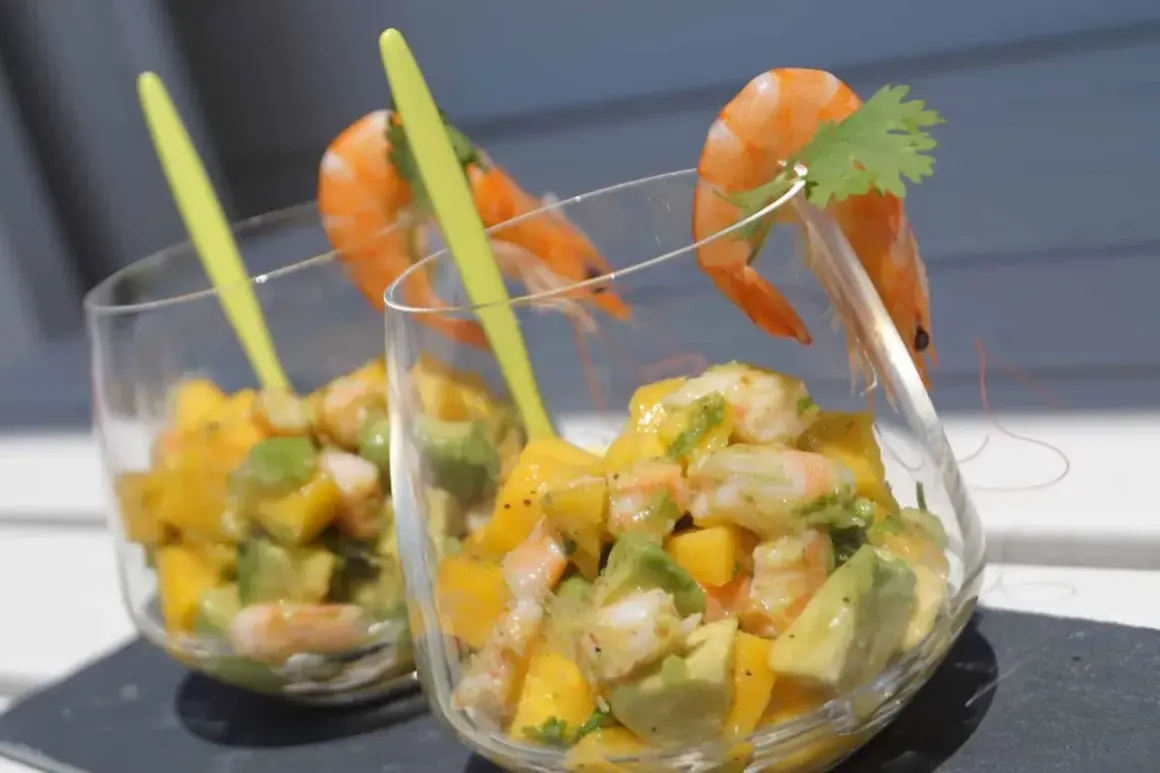 Verrine avocat saumon : deux coupes remplies d'un mélange coloré d'avocat, de mangue et de crevettes, garnies d'une crevette et d'une feuille de coriandre.