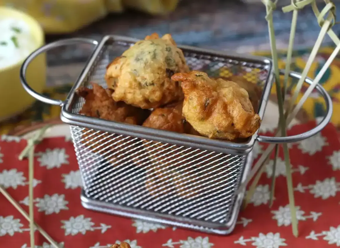 Accras de morue antillais dorés et croustillants dans une petite friteuse. Parfait pour une recette antillaise.