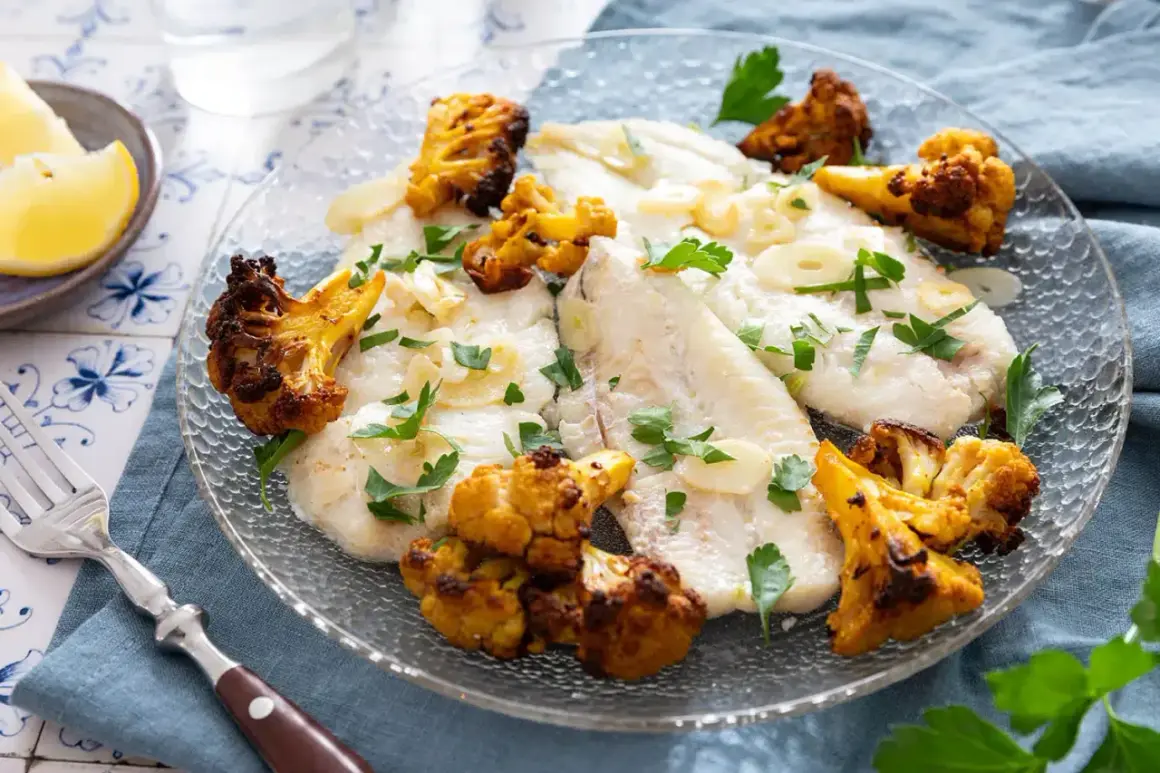 Délicieux poisson aiglefin poêlé, servi avec du chou-fleur rôti et garni de persil frais.