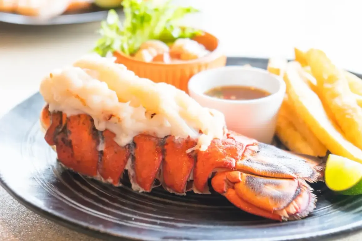 Un succulent homard grillé, accompagné de frites croustillantes, d'une sauce savoureuse et d'une touche de citron vert.