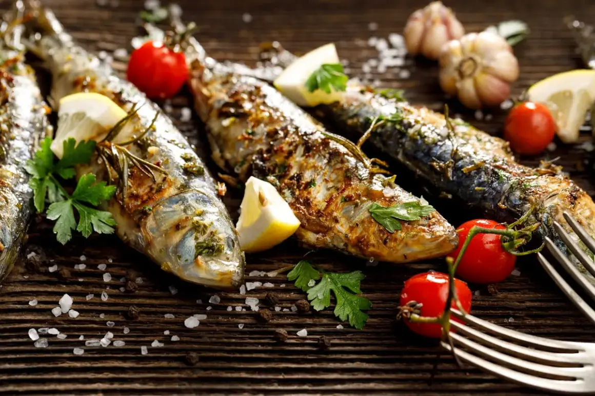 Sardines grillées, citron, tomates cerises, ail et persil sur fond de bois. Faut-il vider les sardines avant de les cuire ? La réponse est dans l'assiette !