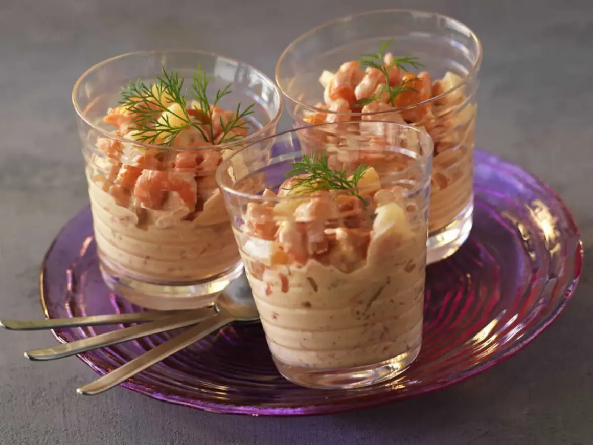 Trois verrines garnies de crevettes et d'une onctueuse sauce cocktail, décorées d'aneth.