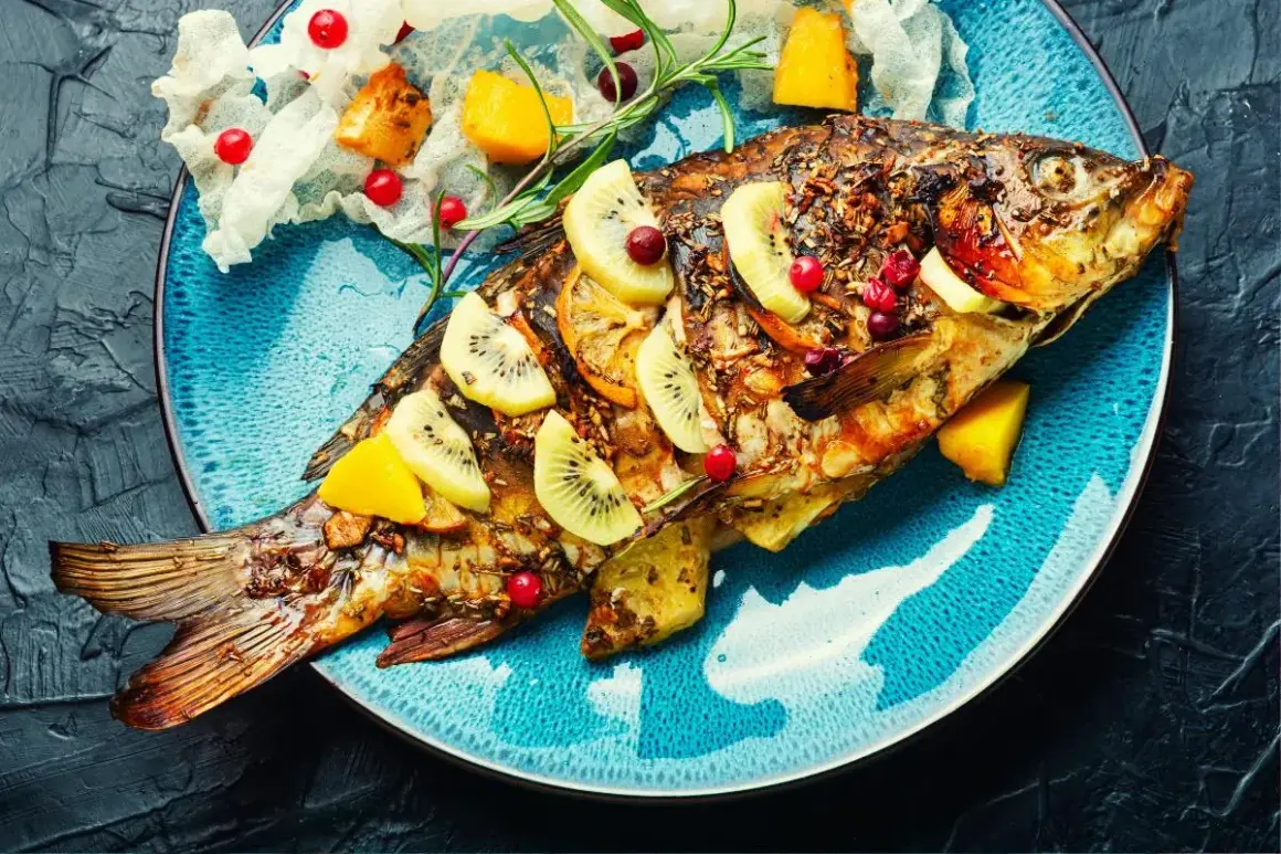 Poisson entier rôti, garni de tranches de kiwi, d'orange et de canneberges. Une belle recette poisson pour un repas festif.