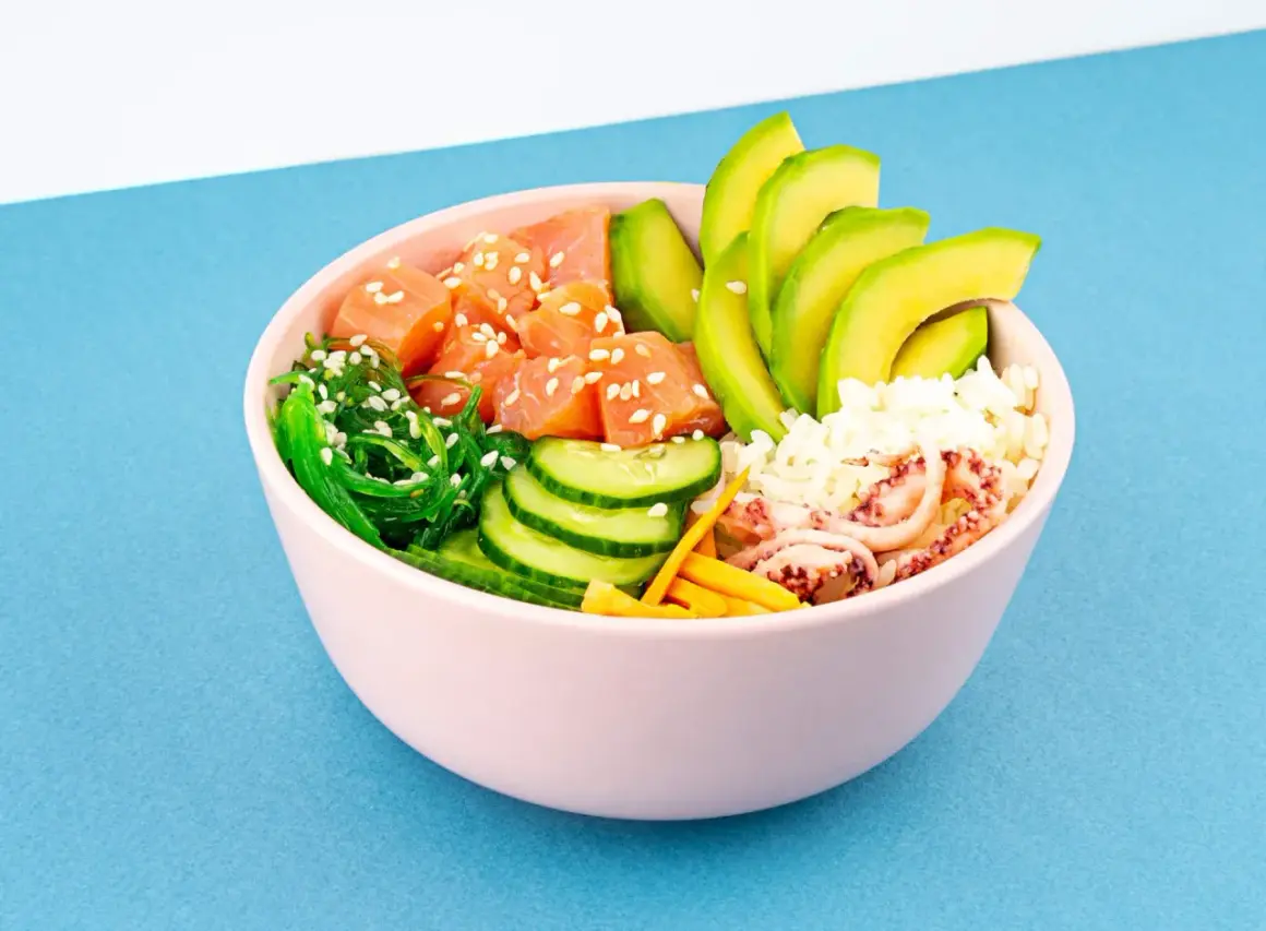 Un délicieux poke bowl avec saumon, avocat, concombre, algues et riz.