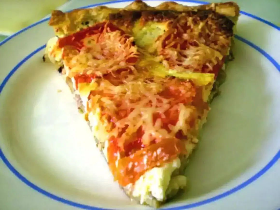 Tranche de tarte au thon, tomates et fromage râpé, parfaite pour une recette tarte au thon facile et savoureuse.