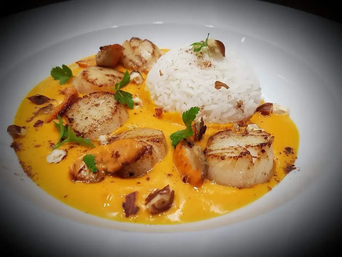 Saint Jacques po&ecirc;l&eacute;es sur un lit de pur&eacute;e de butternut, accompagn&eacute;es de riz blanc et de quelques &eacute;clats de noisettes. Une recette savoureuse et color&eacute;e.
