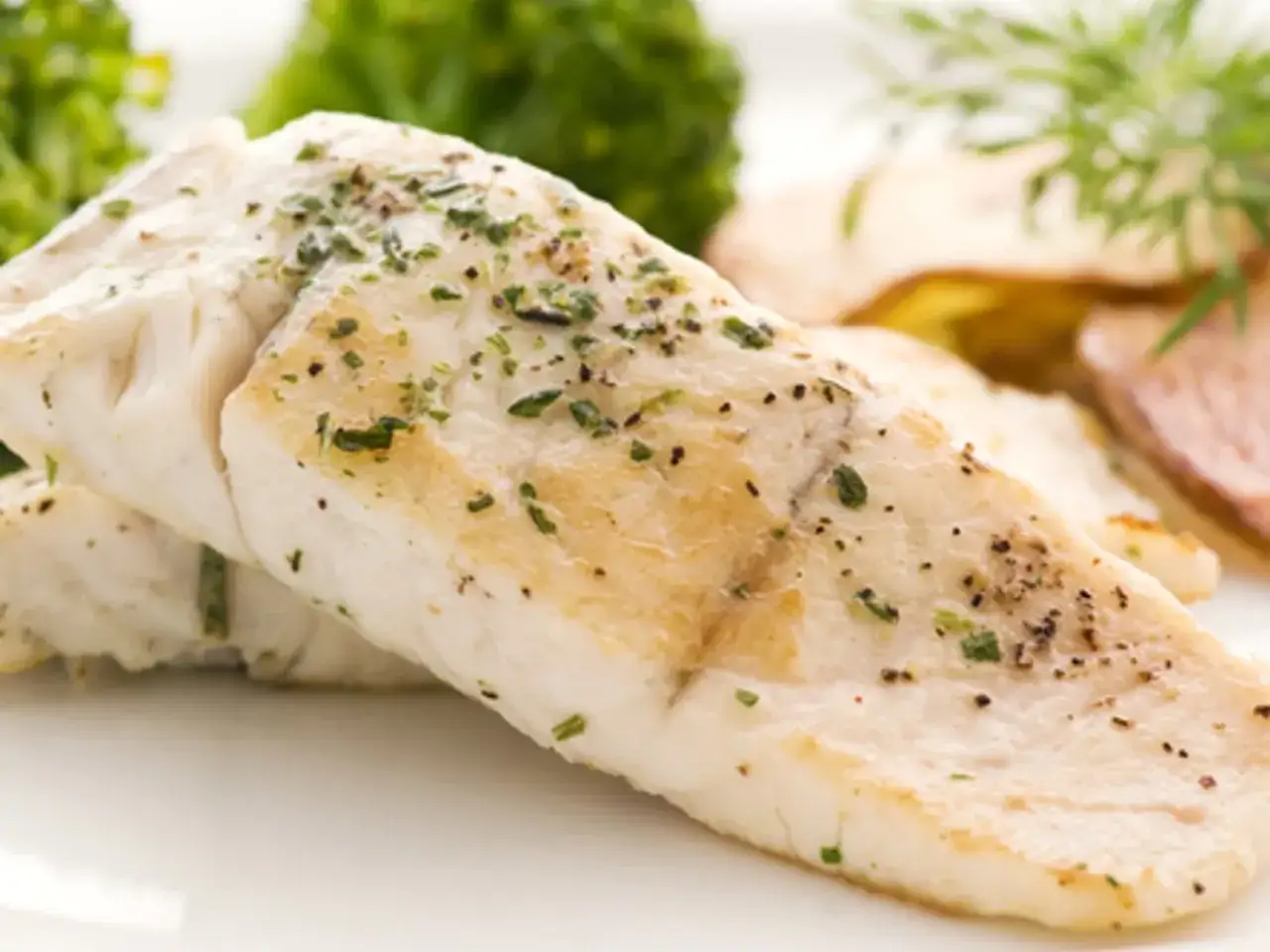 Filet de poisson aiglefin, tendre et savoureux, servi avec des l&eacute;gumes verts et des pommes de terre.