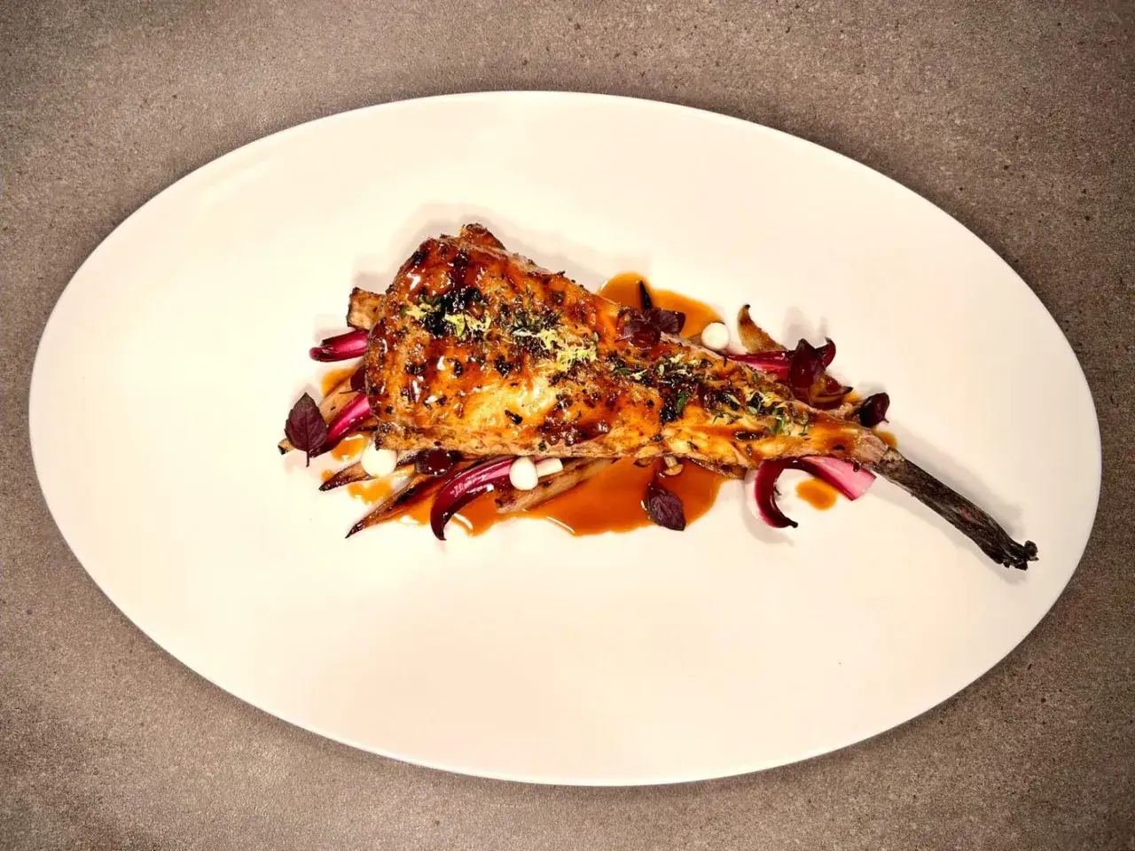 Lotte au barbecue, napp&eacute;e d'une sauce caram&eacute;lis&eacute;e, servie sur des l&eacute;gumes croquants et des &eacute;clats de citron. Un d&eacute;lice visuel et gustatif.