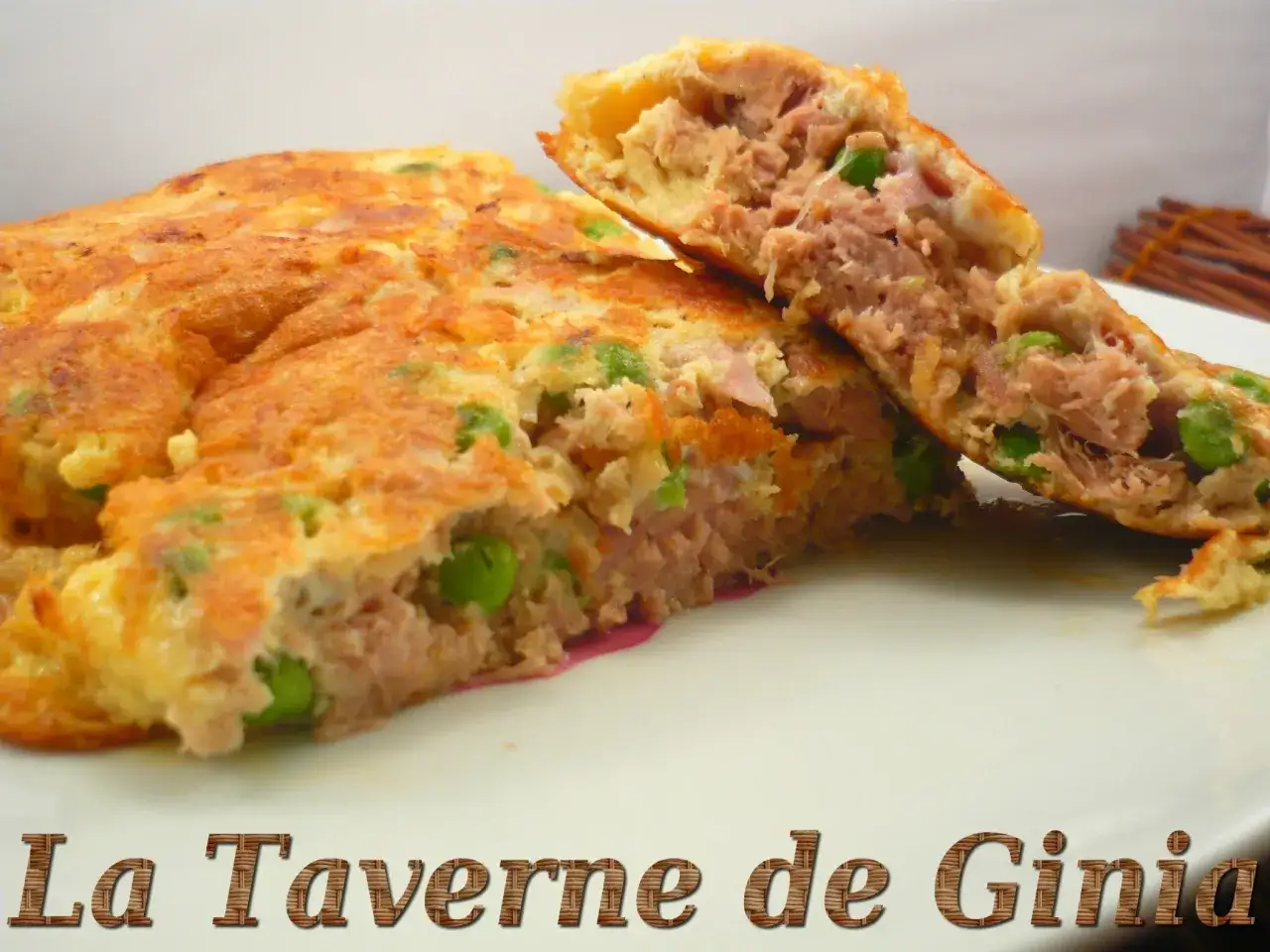 Une savoureuse omelette au thon, garnie de petits pois, coup&eacute;e en deux pour r&eacute;v&eacute;ler sa texture g&eacute;n&eacute;reuse.
