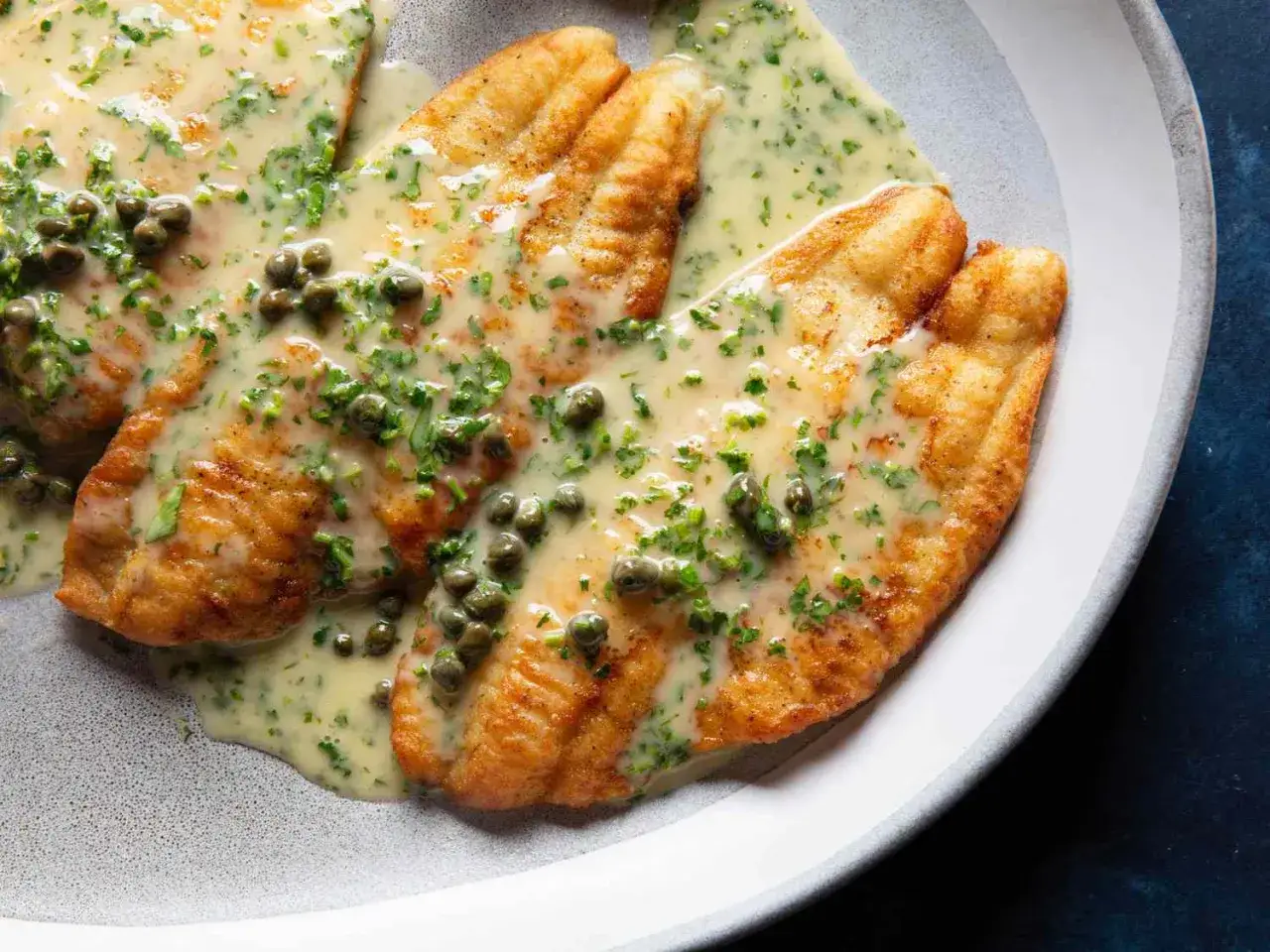 Filets de poisson dor&eacute;s, napp&eacute;s d'une sauce cr&eacute;meuse aux c&acirc;pres et persil. Un accompagnement poisson savoureux et &eacute;l&eacute;gant.