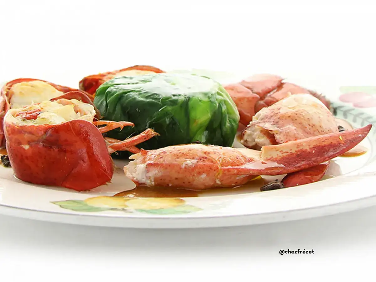 Homard pr&eacute;par&eacute; pour une cuisson court bouillon, servi sur une assiette d&eacute;cor&eacute;e.