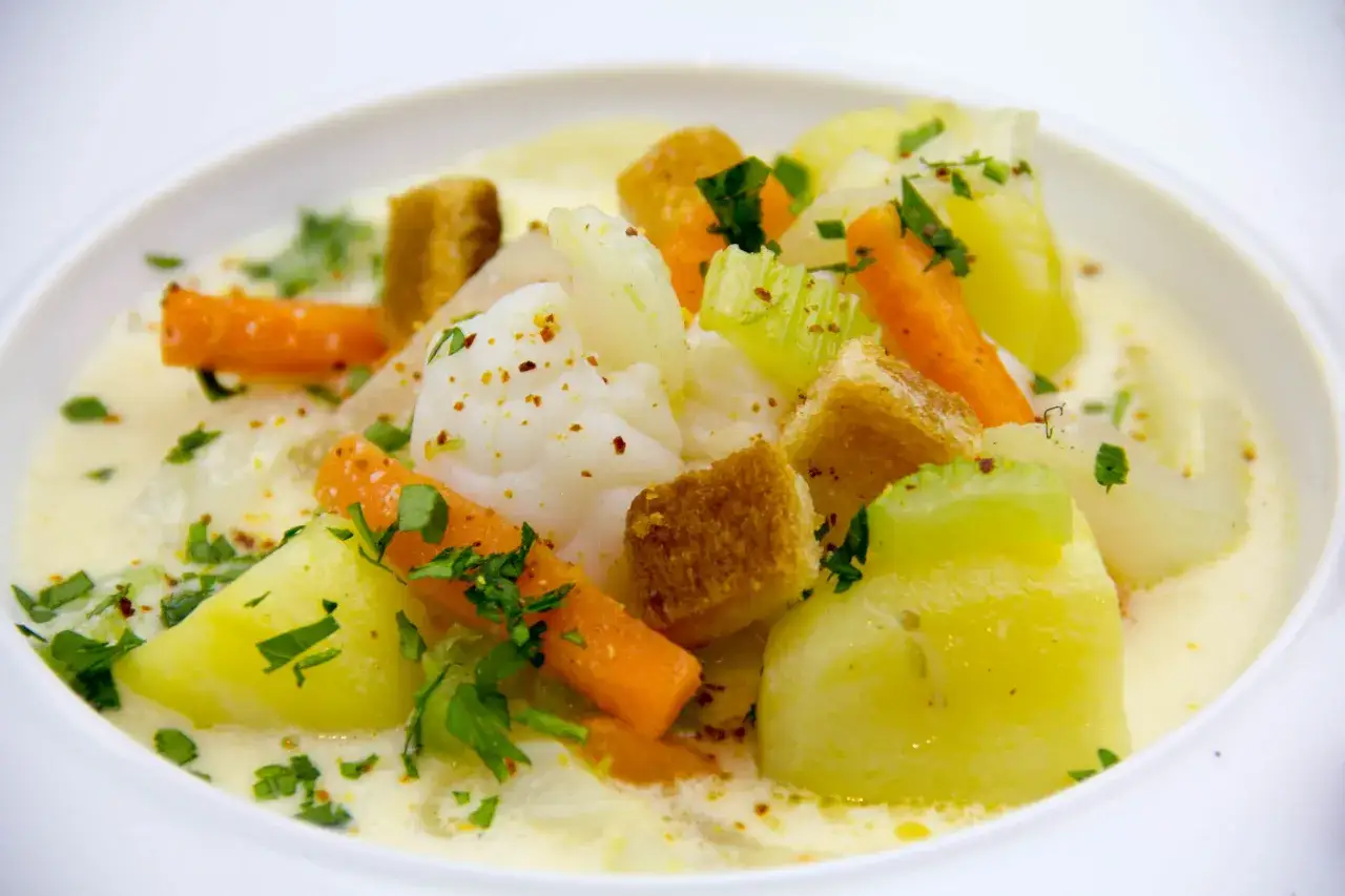 Bourride de lotte : morceaux de poisson blanc, carottes, pommes de terre, c&eacute;leri et cro&ucirc;tons dans une sauce cr&eacute;meuse, parsem&eacute;e de persil frais.