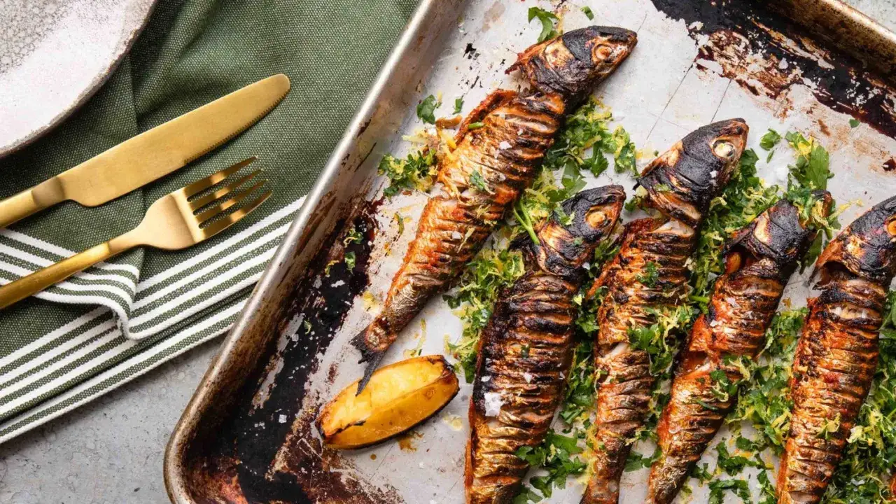 Sardines grillées sur une plaque, garnies d'herbes fraîches. La question