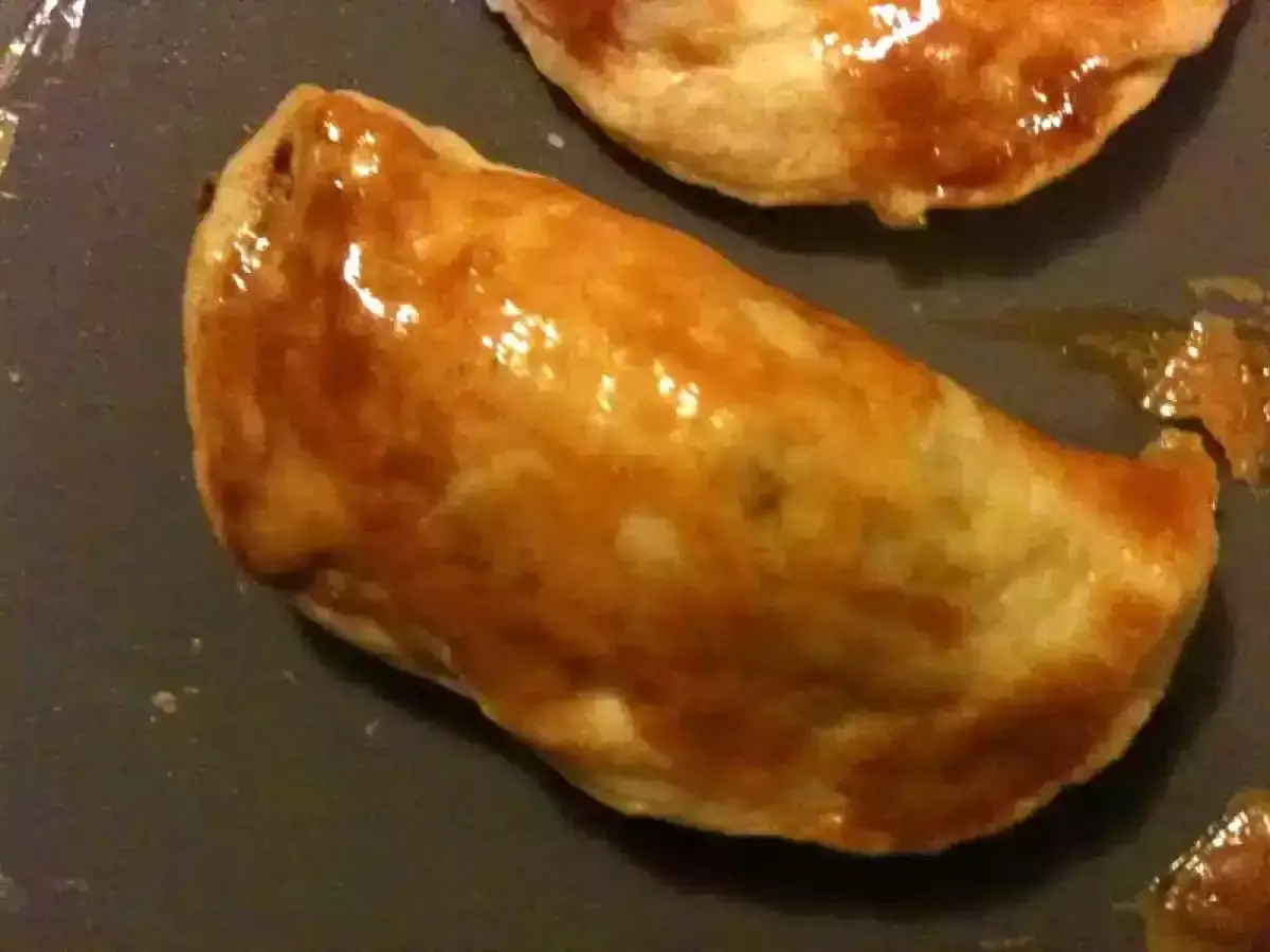 Deux chaussons dor&eacute;s et brillants, un d&eacute;lice de pastel thon, pr&ecirc;ts &agrave; &ecirc;tre d&eacute;gust&eacute;s.