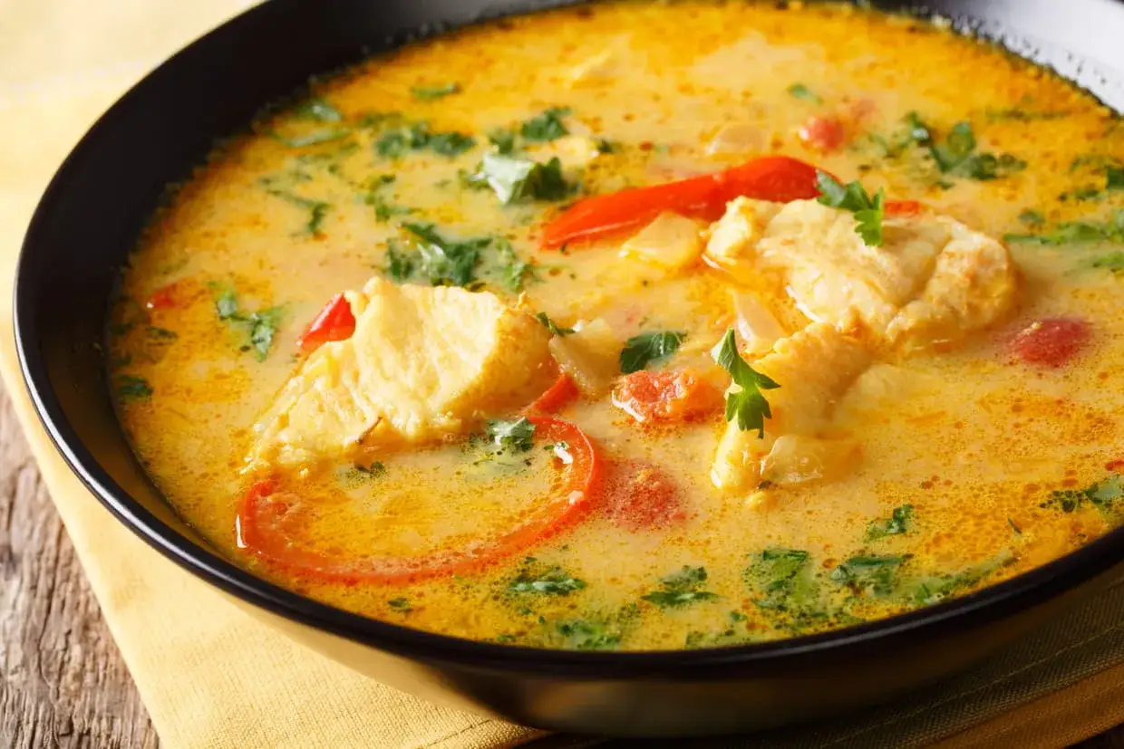 Un plat de poisson cr&eacute;meux avec des morceaux de poisson, des tomates et des herbes, le tout napp&eacute; d'une sauce onctueuse &agrave; la sauce noilly prat.