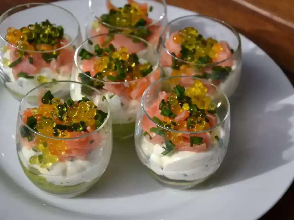 Six verrines avocat saumon, garnies de cr&egrave;me, saumon fum&eacute;, ciboule et perles d'orange et de jaune.