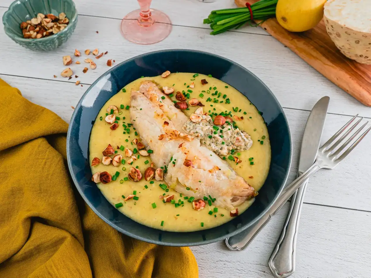 Un plat de poisson savoureux sur un lit de pur&eacute;e cr&eacute;meuse, garni de noisettes croquantes et de ciboulette. Une recette poisson qui invite &agrave; la gourmandise.