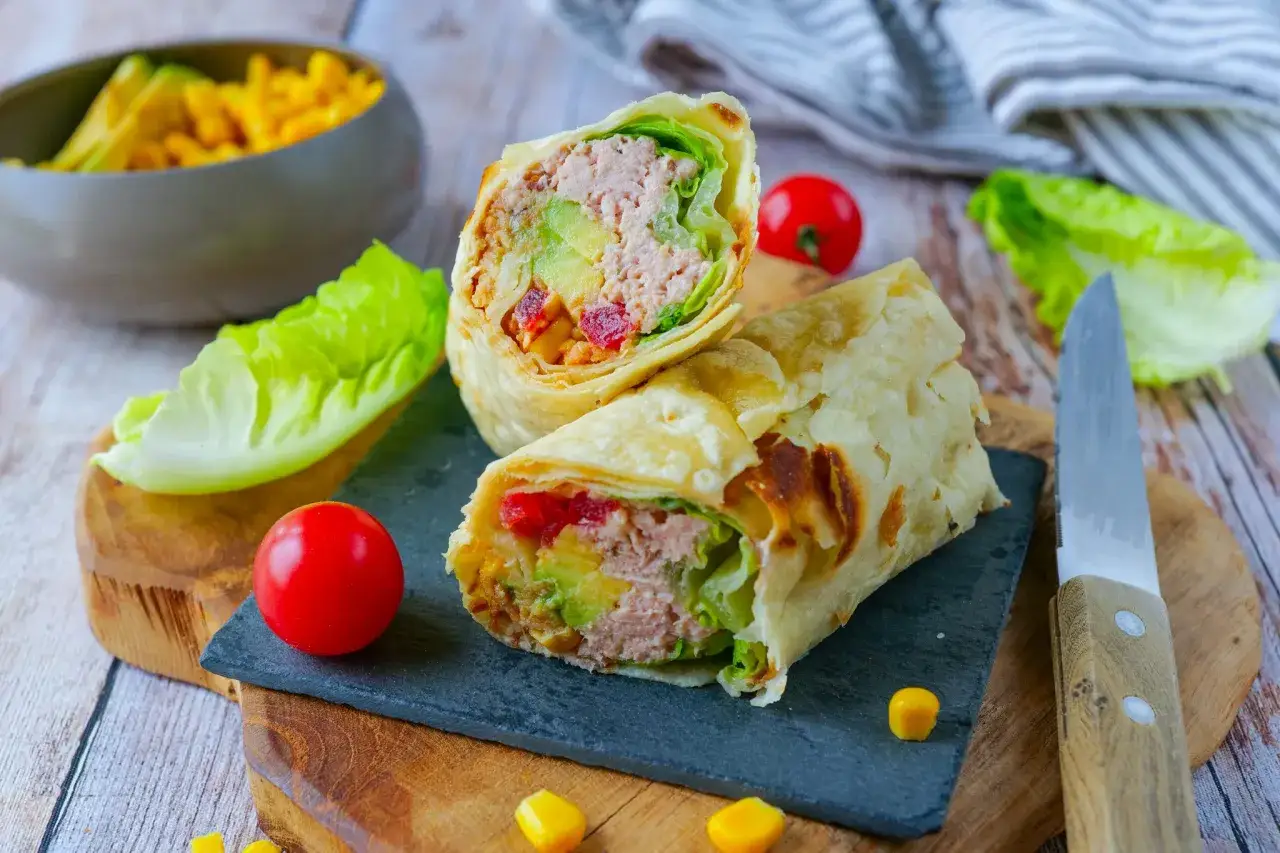 Un d&eacute;licieux wrap thon garni d'avocat, de tomates et de laitue, pr&ecirc;t &agrave; &ecirc;tre d&eacute;gust&eacute;.