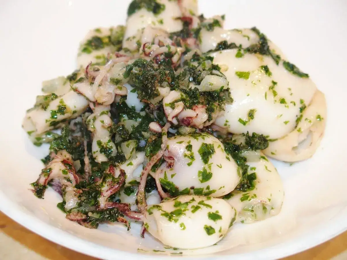 Lamelles d'encornet tendres, po&ecirc;l&eacute;es avec persil frais et ail. Un d&eacute;lice simple et savoureux.