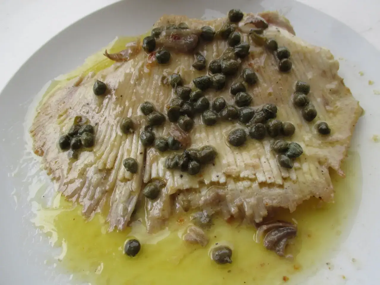 Une aile de raie po&ecirc;l&eacute;e, napp&eacute;e d'une sauce au beurre et garnie de c&acirc;pres. Un d&eacute;lice marin.