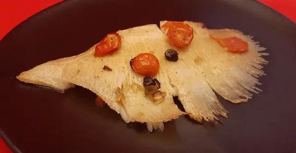 Aile de raie cuite à l'eau, garnie de tomates cerises et d'olives. Le temps de cuisson est parfait pour cette recette.