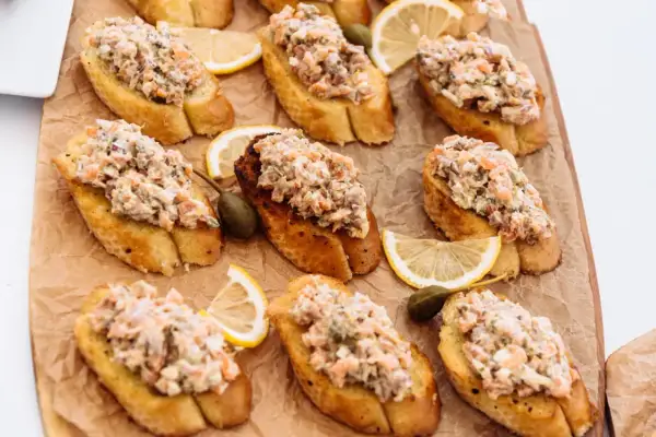 Bruschettas garnies de rillettes de sardines, câpres et quartiers de citron. Un délice pour l'apéritif.