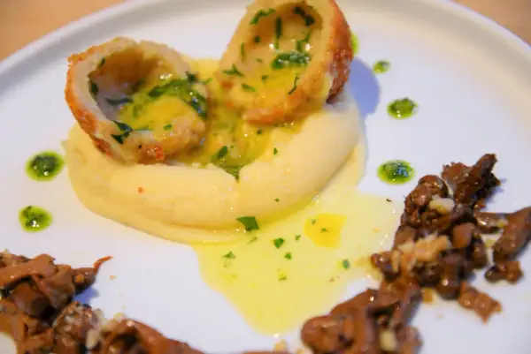 Délicieuse recette de coques farcies, servies sur une purée onctueuse, arrosées d'une sauce au beurre et accompagnées de champignons.