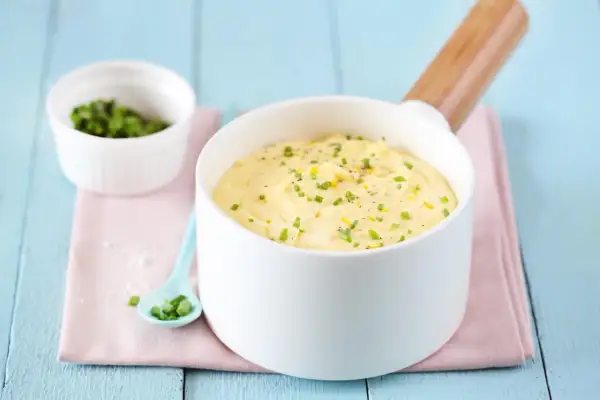 Un bol de beurre citronné (pour poisson) garni de ciboulette et de zeste de citron, prêt à sublimer votre plat.