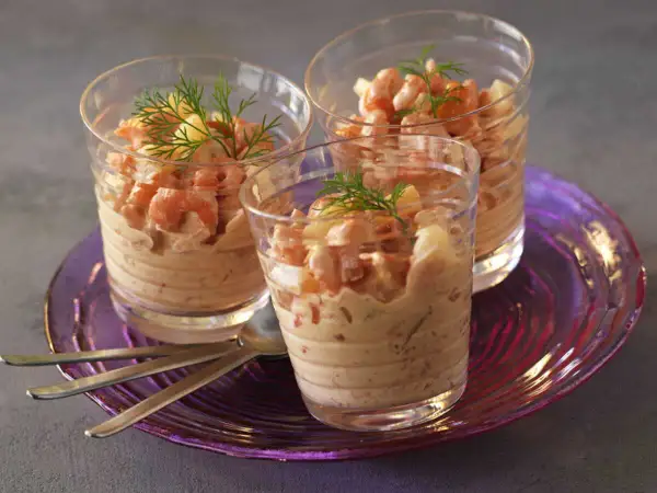 Trois verrines garnies de crevettes et d'une onctueuse sauce cocktail, décorées d'aneth.