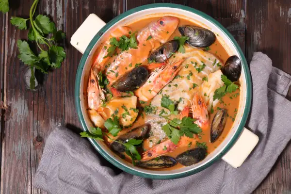 Un plat de bouillabaisse savoureux avec poissons, crevettes et moules, prêt à être dégusté. Une recette authentique pour un repas d'exception.
