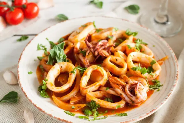 Délicieuse cuisson lamelle d'encornet à la poêle, garnie de persil frais. Un plat savoureux et coloré.