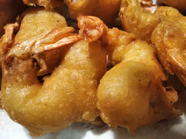 Gros plan sur des beignets de crevette dorés et croustillants, prêts à être dégustés.