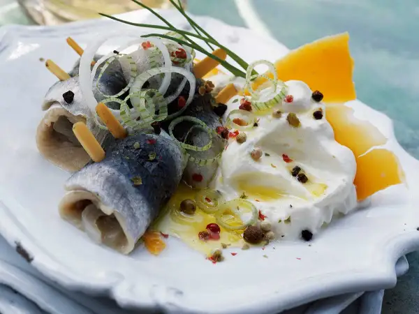 Délicieuse rollmops recette : harengs roulés, oignons, fromage et crème, assaisonnés de poivre et d'herbes.