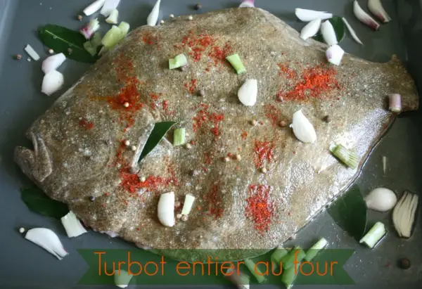 Un turbot entier est préparé pour être rôti au four, assaisonné de paprika, d'ail, d'oignons et de grains de poivre.